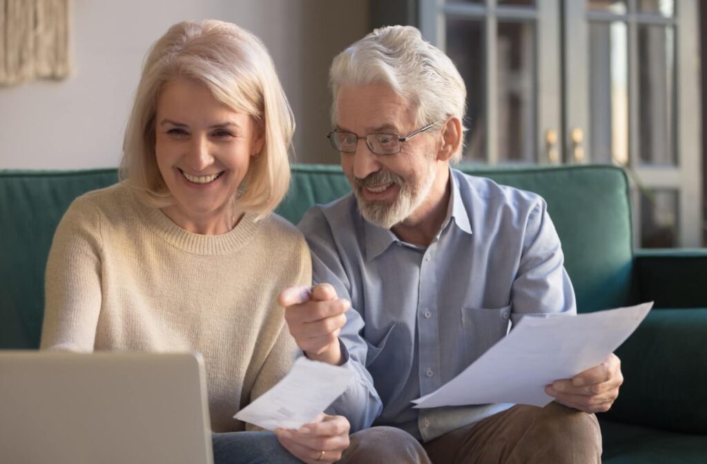 A senior couple uses a laptop to review their medical history as part of the process of applying to assisted living.