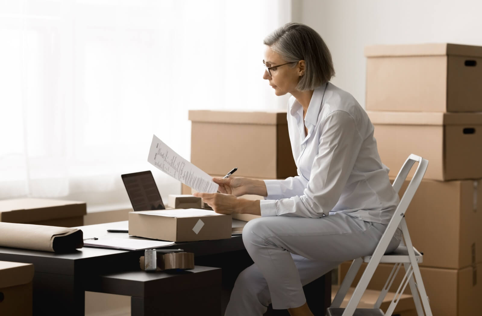 An older adult sorts through important documents to ensure they’re all in the same place during a move to independent living