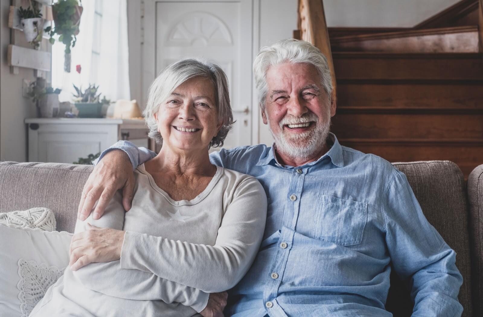 senior couple sitting together on a sofa enjoying their independence in assisted living.